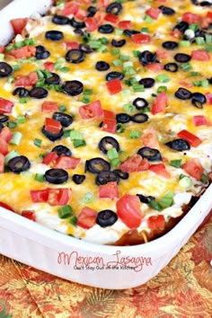 a casserole dish with black olives, tomatoes and green peppers