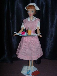 a doll holding a plate with food on it