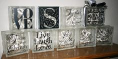 six clear glass blocks with black and white lettering on them sitting on a wooden table