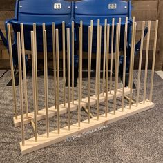 two blue seats sitting next to each other on top of a carpeted floor in front of a wooden fence