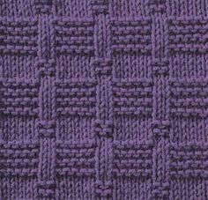 a close up view of a purple knitted fabric with small squares and braids