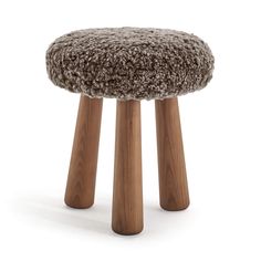 the foot stool is made out of wood and has a furry cushion on top of it