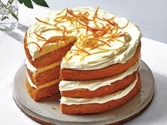 a cake with white frosting and orange sprinkles sits on a plate