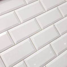 a close up view of a white tile wall