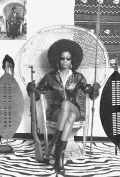 a black and white photo of a woman sitting in a chair surrounded by musical instruments