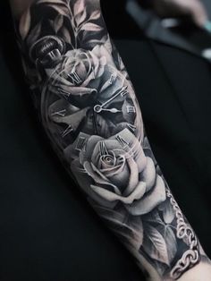 a black and white photo of a clock with roses on it's arm,