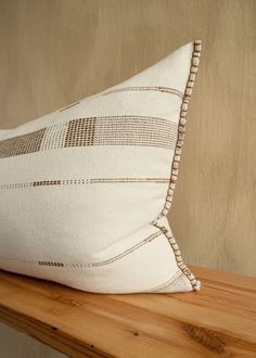 a white pillow sitting on top of a wooden shelf