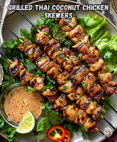 grilled thai coconut chicken skewers on a plate with lettuce and sauce