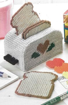 a crocheted toaster sitting on top of a table next to some markers