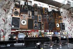 many speakers are hanging on the wall behind a bar