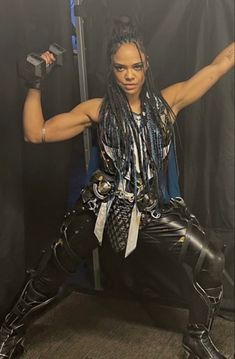 a woman with dreadlocks is posing for a photo in front of a black background