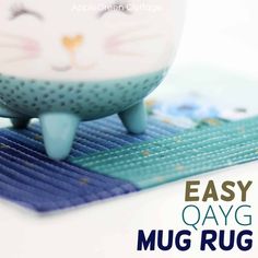 a cat figurine sitting on top of a mat with the words easy oyg mug rug