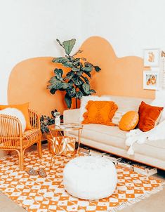 an orange and white living room with two couches, a coffee table and a potted plant