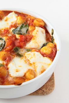 a white bowl filled with food on top of a piece of bread