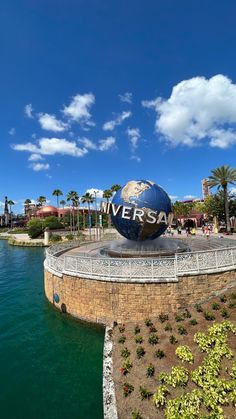 the universal studios sign is shown in front of water and palm trees