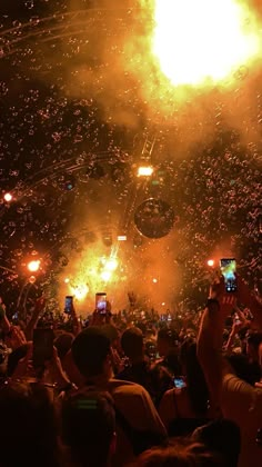 people are watching fireworks and confetti being thrown in the air at an event