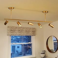 a bathroom with three lights hanging from the ceiling and a sink in front of a window