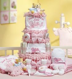 a baby girl crib cake with teddy bears and other items on the bed in front of it