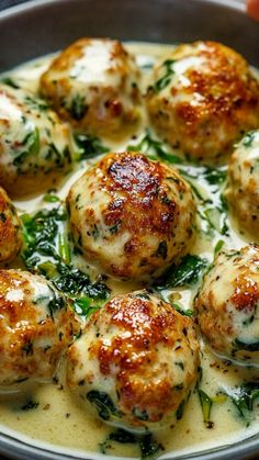 a pan filled with meatballs covered in cheese and spinach