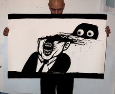 a man holding up a drawing of a monster