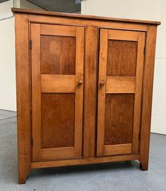 a wooden cabinet sitting on top of a cement floor