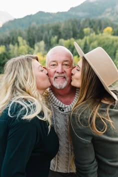 two women and an older man kissing each other