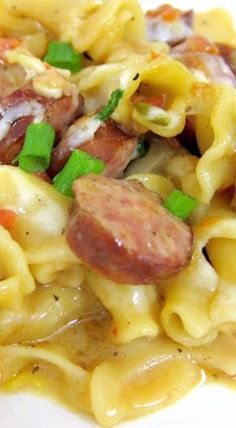 pasta with sausage and green onions on a white plate