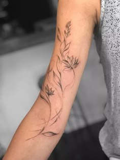 a woman's arm with a flower tattoo on the left side of her arm