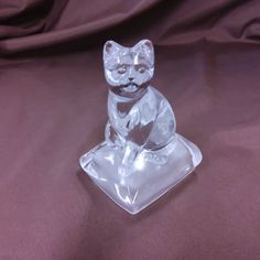 a glass cat sitting on top of a table