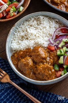 two bowls filled with rice, meat and veggies on top of a wooden table