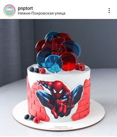 a spiderman themed cake with red, white and blue decorations on it's side