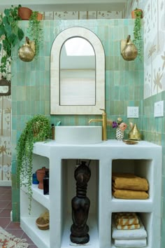 a bathroom with green tile and gold accents