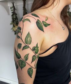 a woman with green leaves on her arm