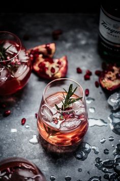 pomegranates are garnished with rosemary on top of the glasses