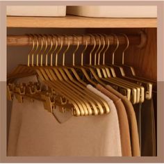 an open closet with clothes hanging on hangers