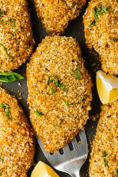 several pieces of breaded chicken with lemon wedges