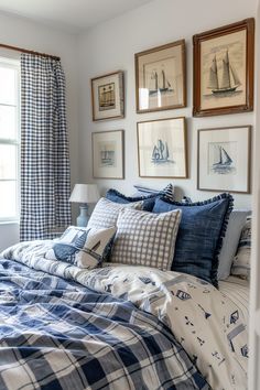 a bedroom with blue and white bedding, pictures on the wall and window sill