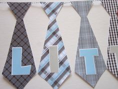 four ties with the letter l on them hanging from a line in front of a white wall