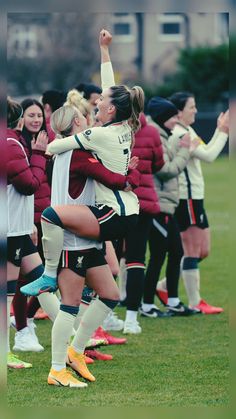 the soccer players are hugging each other in front of their team mates on the field