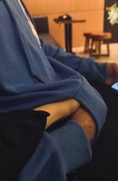 a man sitting in a chair with his arms folded over his chest and laptop on his lap