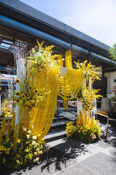 yellow flowers are hanging from the side of a building