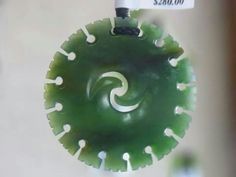 a green object hanging from a hook on a wall with a price tag attached to it