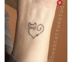 a small cat tattoo on the wrist