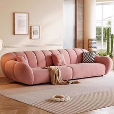 a pink couch sitting on top of a wooden floor