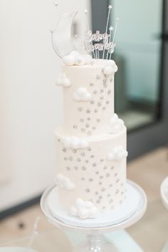 a three tiered white cake with stars and moon decorations