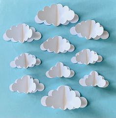 paper clouds are arranged on a blue background