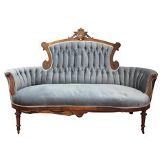 an old fashioned couch with blue velvet upholstered