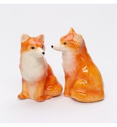 two ceramic foxes sitting next to each other