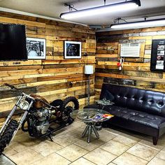 a motorcycle is parked next to a couch in a room with wood paneling on the walls