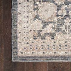 an area rug on a wooden floor with dark brown wood floors and white and blue accents